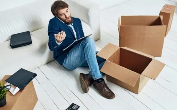 man-sitting-on-floor-unpacking-while-working